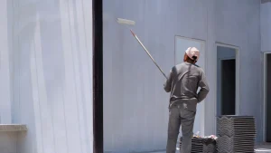 Painter applying primer to an interior wall before repainting to ensure better adhesion