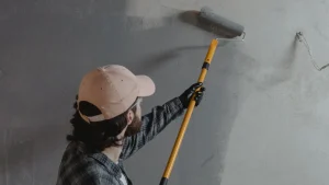 Painter applying standard exterior paint to wood siding