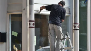 Painter working on home exterior in summer