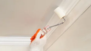 Painter applying paint to an interior ceiling
