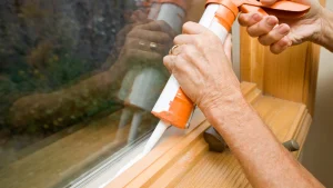 Applying new caulk to exterior trim
