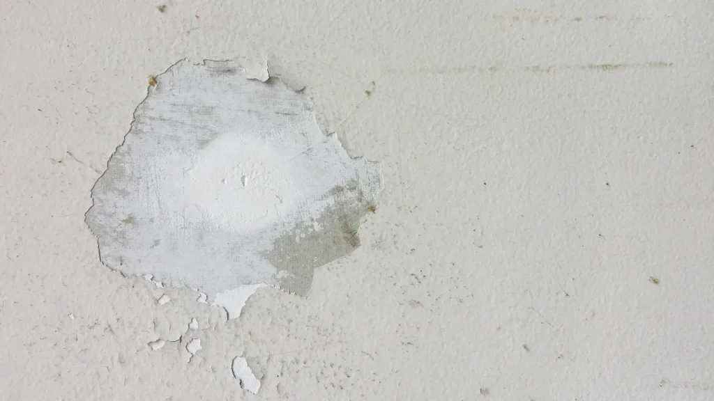 Repaired drywall nail pop before interior wall painting