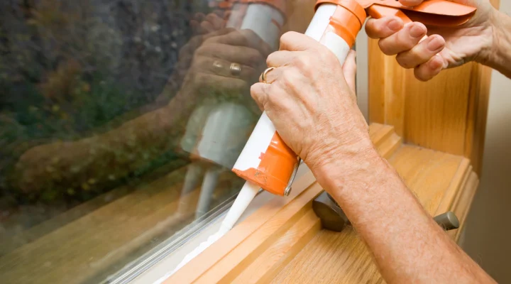 Applying new caulk to exterior trim