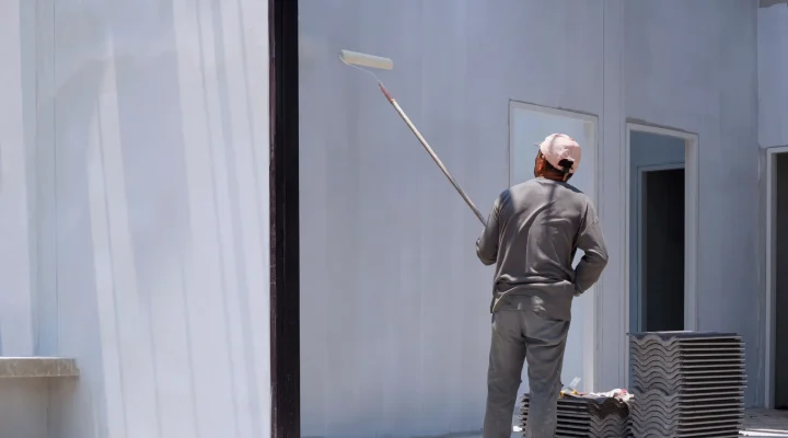 Painter applying primer to an interior wall before repainting to ensure better adhesion