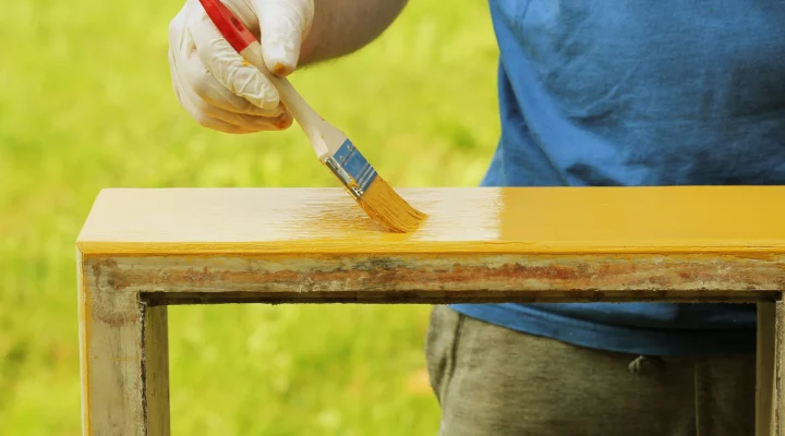 Painter applying paint over stained wood without sanding first