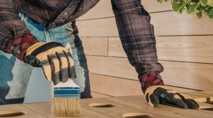 Contractor applying stain to a wood deck