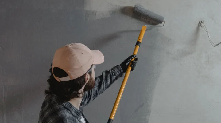 Painter applying standard exterior paint to wood siding